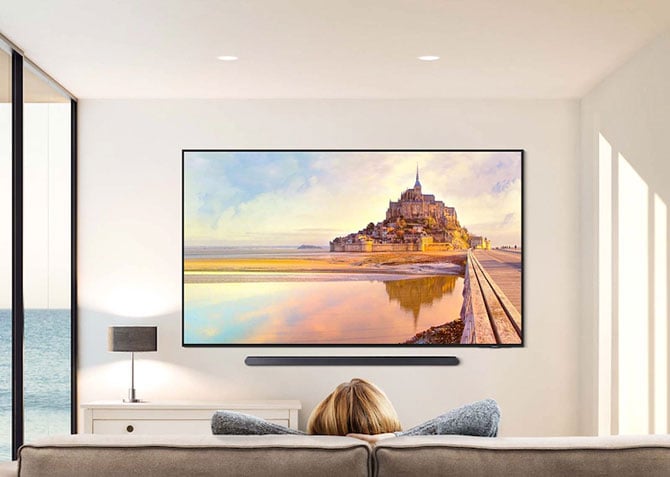 Samsung's 98-inch QN90D is shown mounted on a wall.