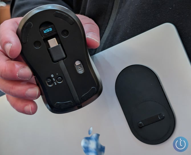 The ESR HaloLock MagMouse is shown with the bottom facing the camera and you can see the mounting pad on a MacBook Air in the background. 