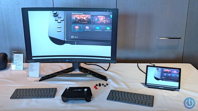 Lenovo Legion Go shown in the USB-C Dock attached to a monitor with the controllers attached to the Connector in front with extra joystick caps.