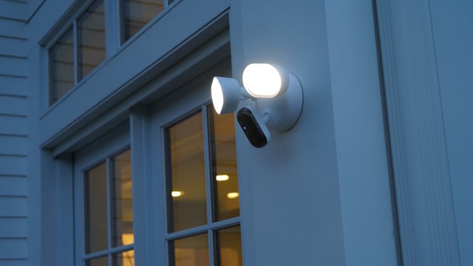 Arlo Wired Floodlight Camera is mounted on the outside of a home.