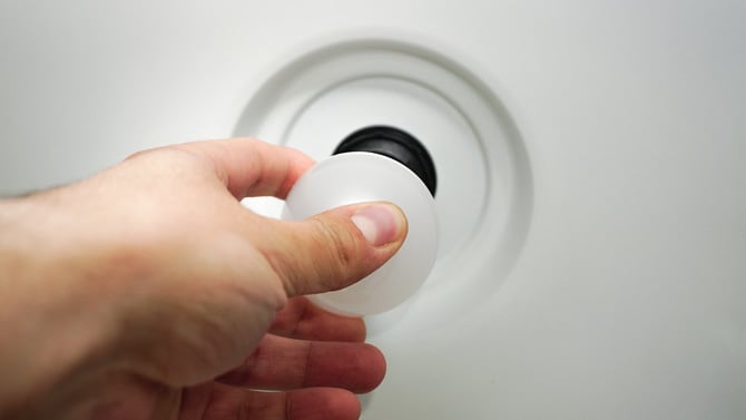 Closeup image of a hand changing a lightbulb