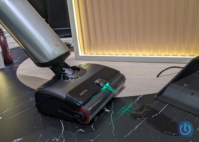 Mova X4 Pro Wet and Dry Vacuum spraying water on a floor highlighted by light