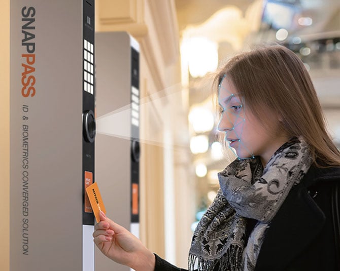 A woman uses a Snappass kiosk, which is shown using face detection to authenticate her.