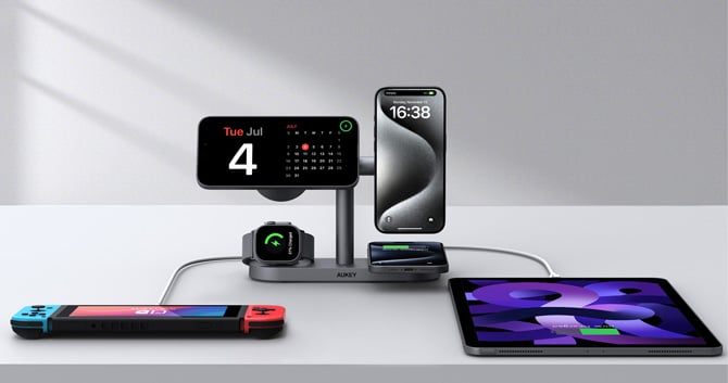 Aukey MagFusion Titan 6-in-1 Charger with three phones and a smartwatch charging wirelessly with a game system and tablet plugged in