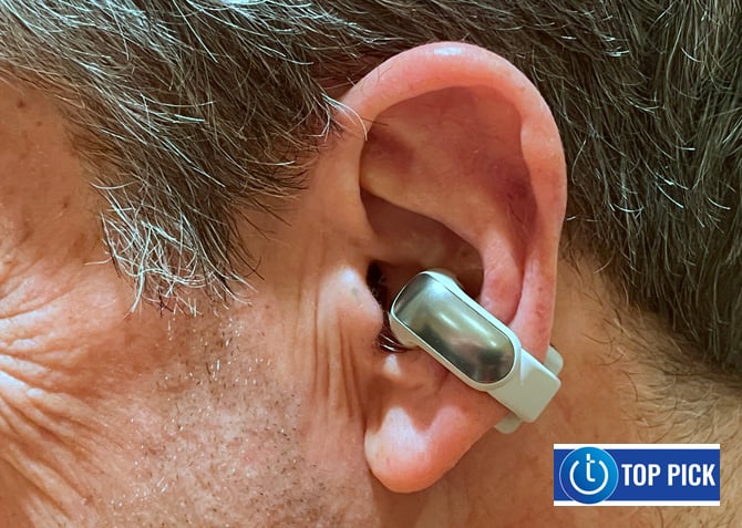 The Bose Ultra Open Earbuds are shown worn on the ear with a Techlicious Top Picks award logo in the lower right corner