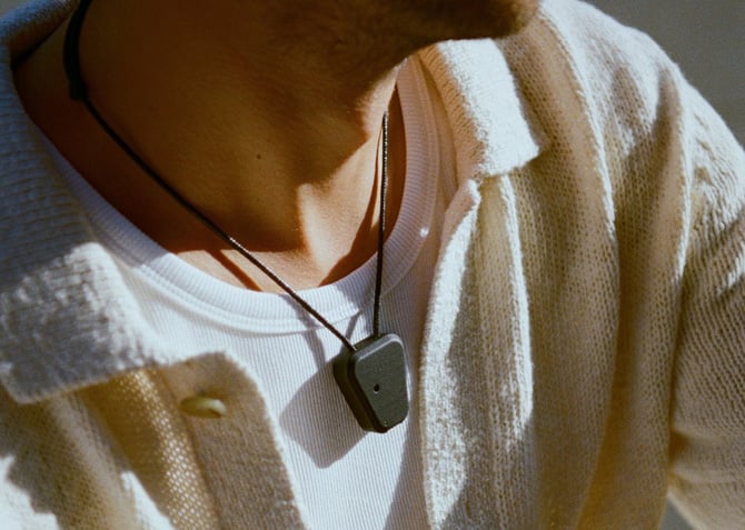 Compass Wearable is shown worn around a person's neck